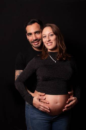 embarazada y su pareja fondo negro ropa casual, en interior