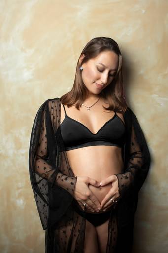embarazada con ropa interior negra y bata transparente negra, en interior