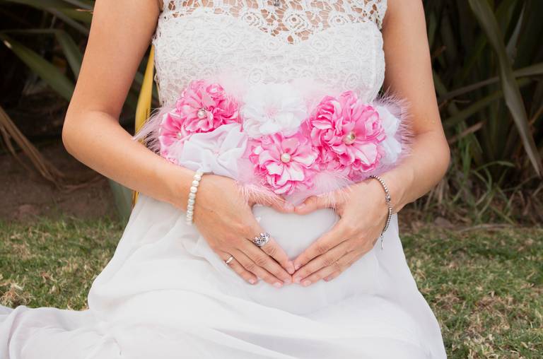 embarazada primer plano panza con manos en coracán, en exterior