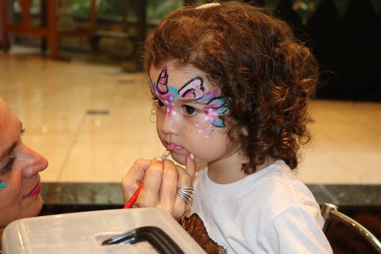 chica maquillando a una niña