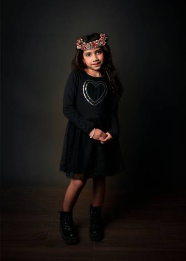niña con vestido negro y corona de flores en la cabeza fineart
