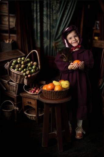 niña vestuario vintage en un granero con frutas fine art