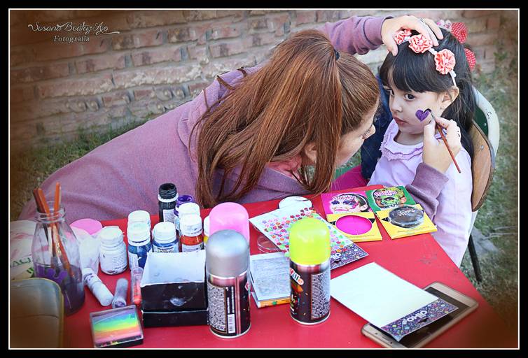 chica maquillando a una niña
