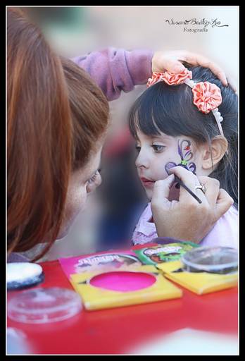 chica maquillando a una niña