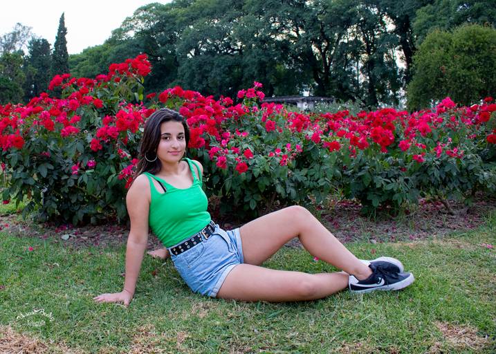 quinceañera sentada delante de rosas rojas