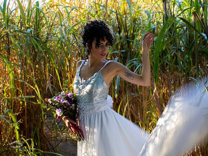 novia parada con ramo y desplegando el vestido