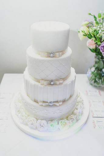 Torta de casamiento blanca tres pisos con moños