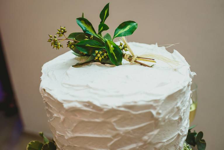 detalle de torta de casamiento blanca con hojas verdes