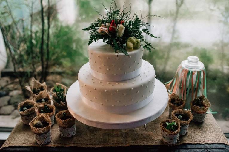 Mesa decorada de casamiento con torta y souvenirs cactus