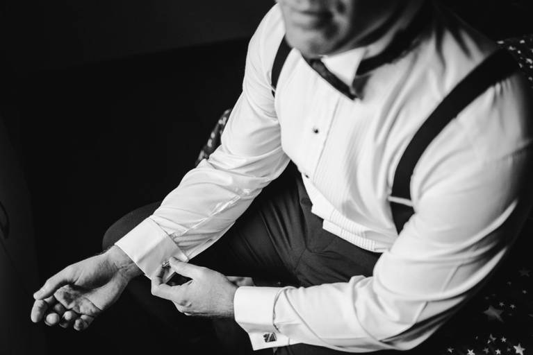 novio se acomoda un gemelo de casamiento