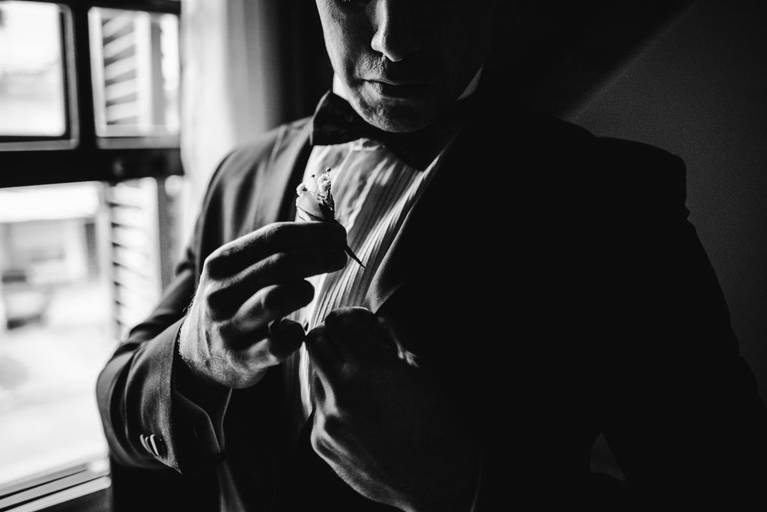 novio coloca butonie en su saco de casamiento