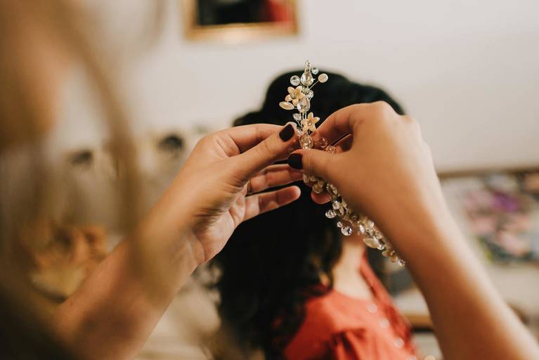mujer pone accesorio en el pelo de novia 