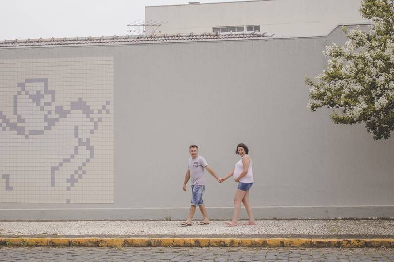 casal caminhando durante sessão de fotos em calçada com ladrilho de anjo