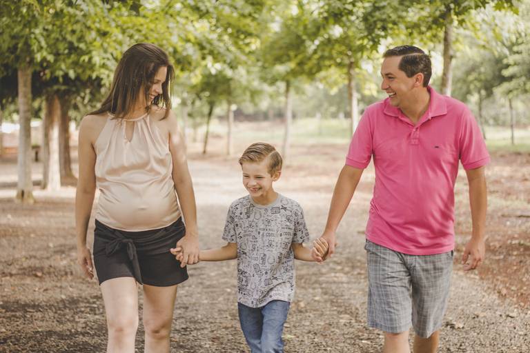 pai, mãe e filho caminhando no anila durante sessão de fotos
