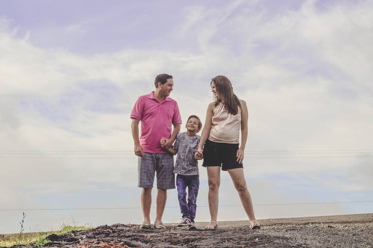 foto de céu azul com pai, mãe e filho juntos esperando bebe