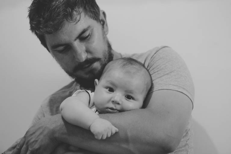Bebe sobre o braço do pai em foto de pai e filho irati pr