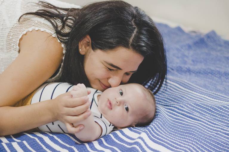mãe dando um cheiro no bebe em momento de cafune