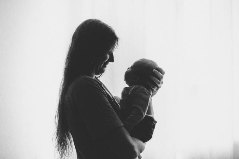 foto preta e branco contra luz de janela em casa mamãe e bebe em irati pr