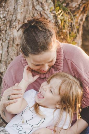 momento mãe e filha rindo juntas aproveitando solzinho de inverno