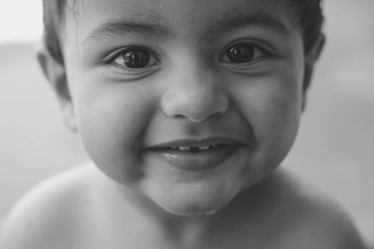Retrato de rostinho de bebe sorrindo em banho de bacia