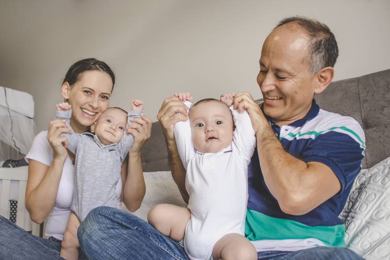 irmãos gêmeos brincando com os pais