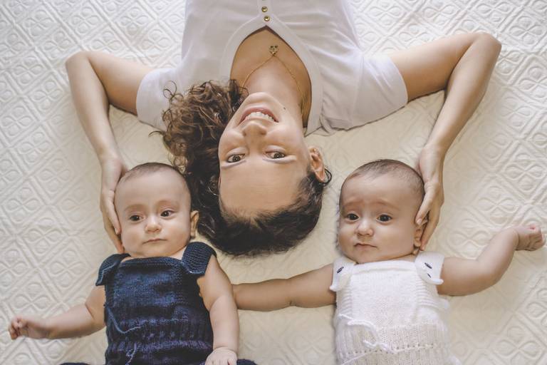 mãe e gêmeos na cama cheios de fofura 