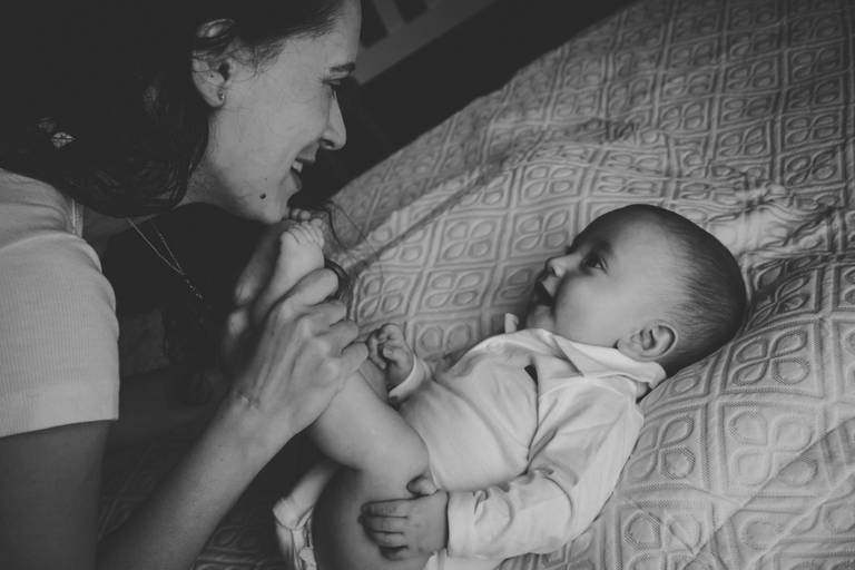 mãe e bebe trocando olhares sobre a cama