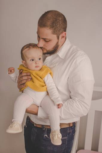 pai de menina dando beijo na bebe