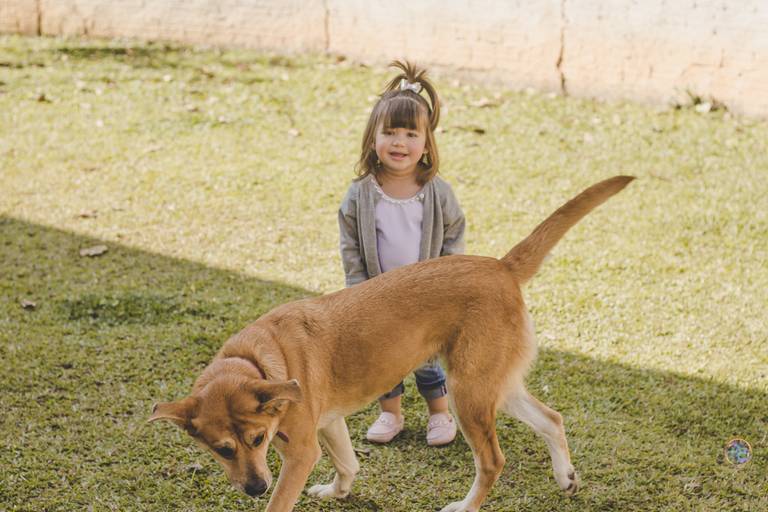 criança brincando com seu animal de estimação no quintal de casa