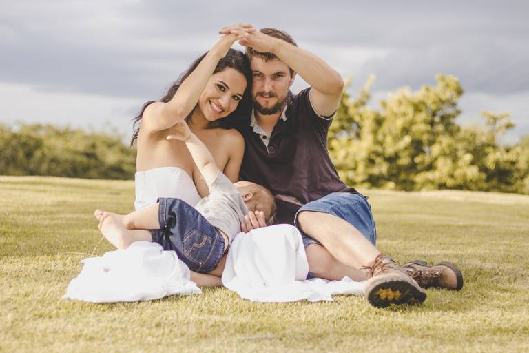 família fazendo casinha com os braços para foto enquanto bebe mama
