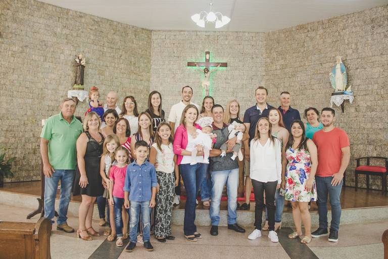 foto com todos os familiares reunidos no altar para celebrar o batismo da bebe irati pr 