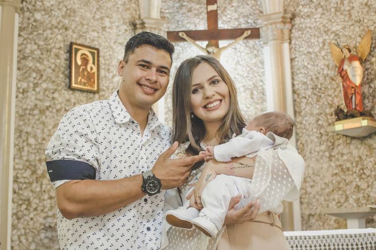Casal de pais católicos felizes em transmitir a fé pelo batismo