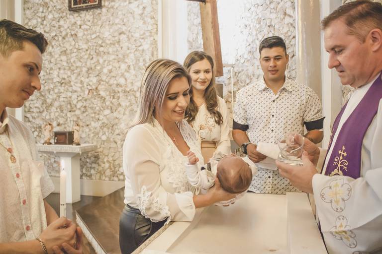 família reunida ao lado da pia batismal