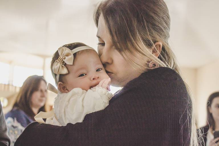 mamae  beijando sua bebe no batismo