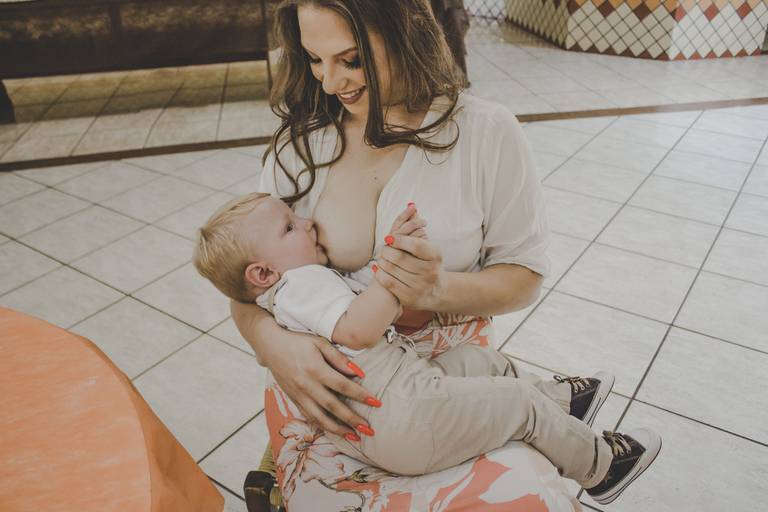 mãe amamentando bebe durante aniversário