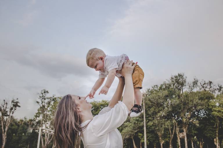foto de bebe tocando o nariz da mamãe em cenário externo