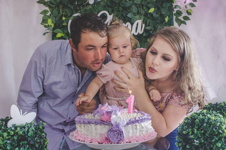 família assoprando velinhas em aniversário de um aninho