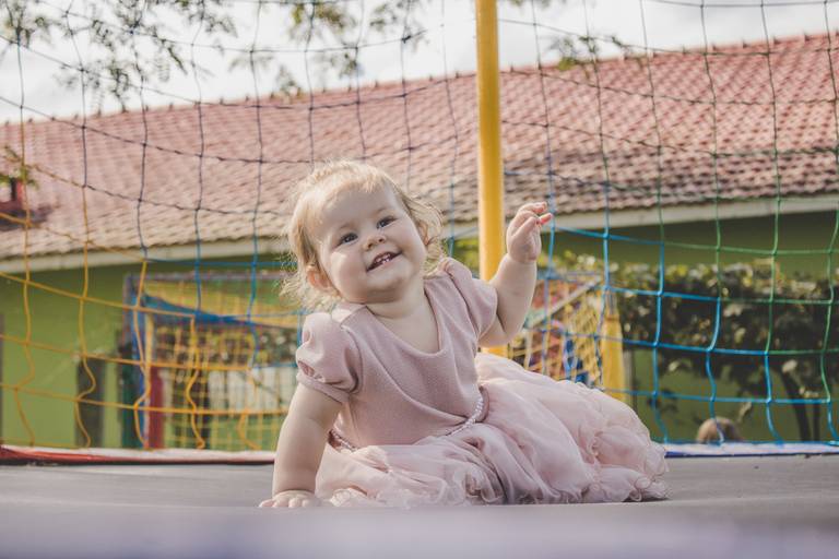 bebe sorrindo enquanto brinca em cama elástica em irati pr