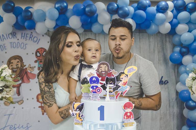 pais soprando velinha em aniversário com tema de jesus maior herói de todos