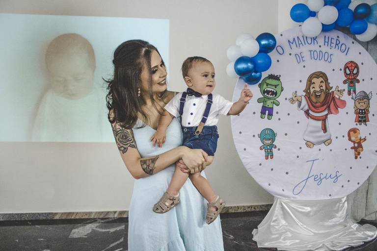 bebe mostrando um aninho em festa com tema de jesus maior herói de todos e foto de denise moletta