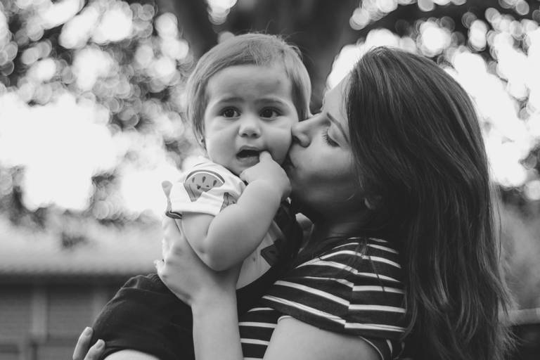 Foto preta e branca com fundo desfocado com tia beijando sobrinha em Irati Pr