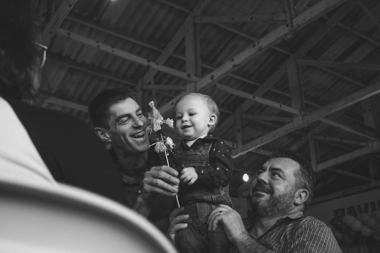 foto em preto e branco de bebe brincando com espantalho na festa infantil