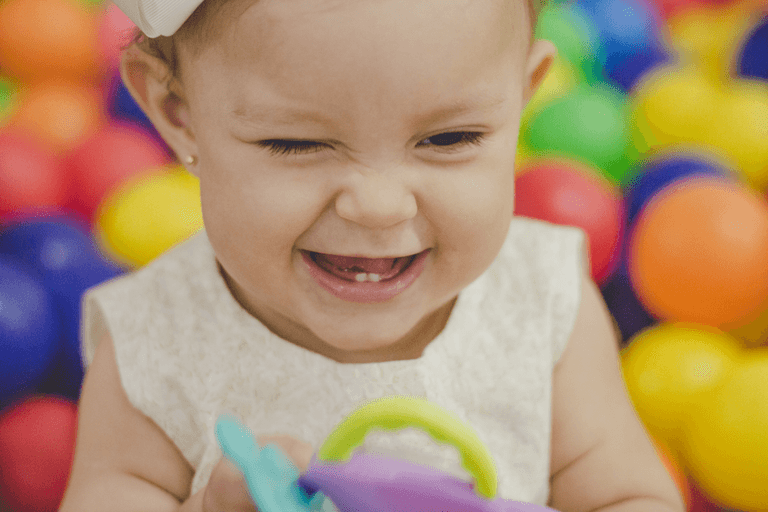 criança com cara de sapeca mostrando os dentinhos