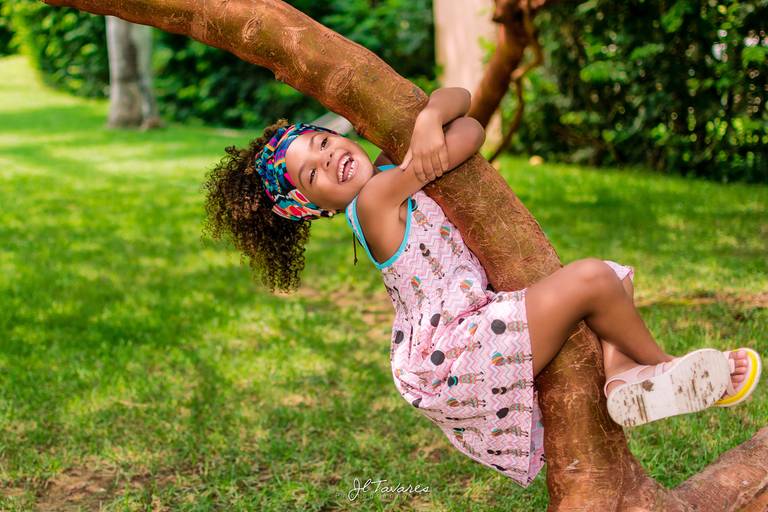 Ensaio fotografico infantil no Rio 2 Park. Menina subindo na árvore.