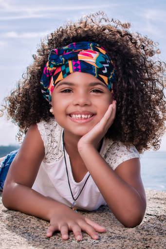 ensaio fotografico infantil com menina de cabelos cacheados na praia de grumari.
