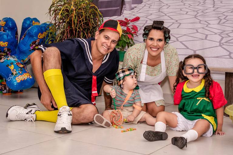 Família fantasiada de Turma do Chaves, pai fantasiado de Kiko, mãe de Dona Florinda, filho de Chaves e priminha de Chiquinha.
