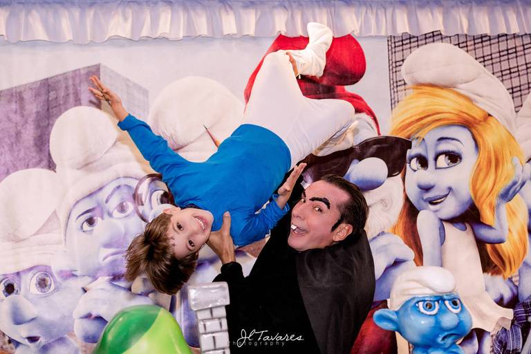 Leandro fantasiado de Smurf em sua festa de aniversário sendo levantado pelo Gargamel