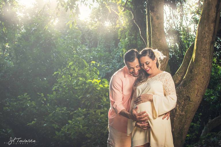 casal gestante abraçado sob a luz que sai das árvores no bosque da barra, barra da tijuca / Rio de Janeiro.