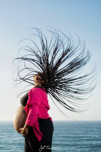 Maise Santana, ensaio gestante criativo com os cabelos dreadbox em movimento na praia de grumari.
