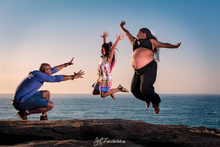 Ensaio Gestante Criativo com gestante e filha pulando e o pai fazendo cara de desespero.